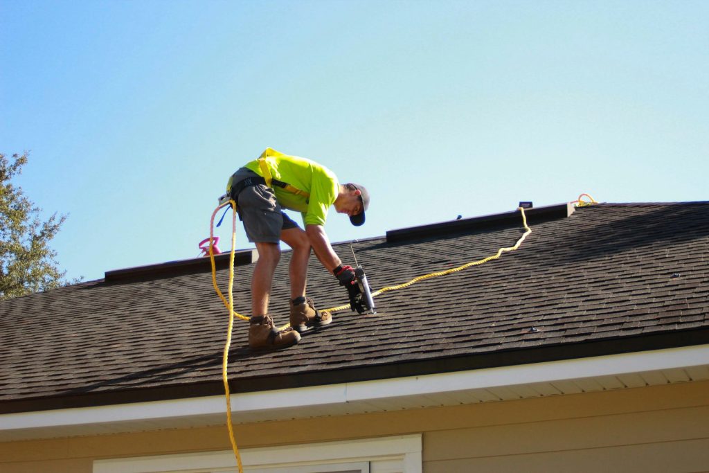 Roofer installing shingles on a home